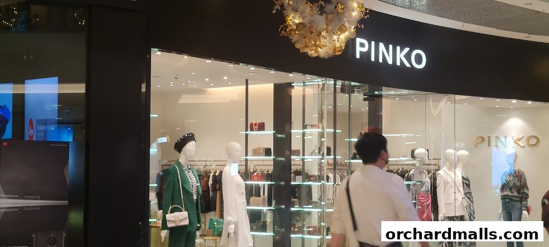 The exterior of a Pinko fashion store with mannequins displaying outfits and handbags.