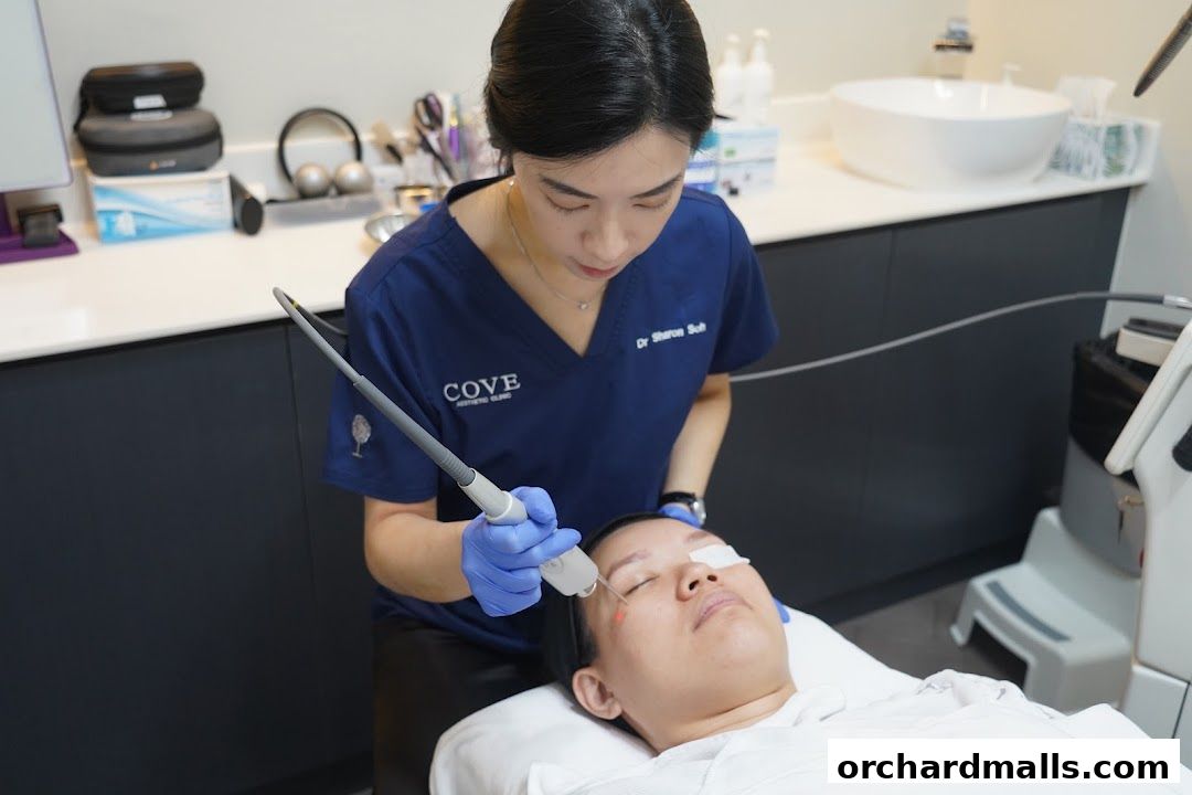 Aesthetician performing a facial treatment on a client with a laser device.