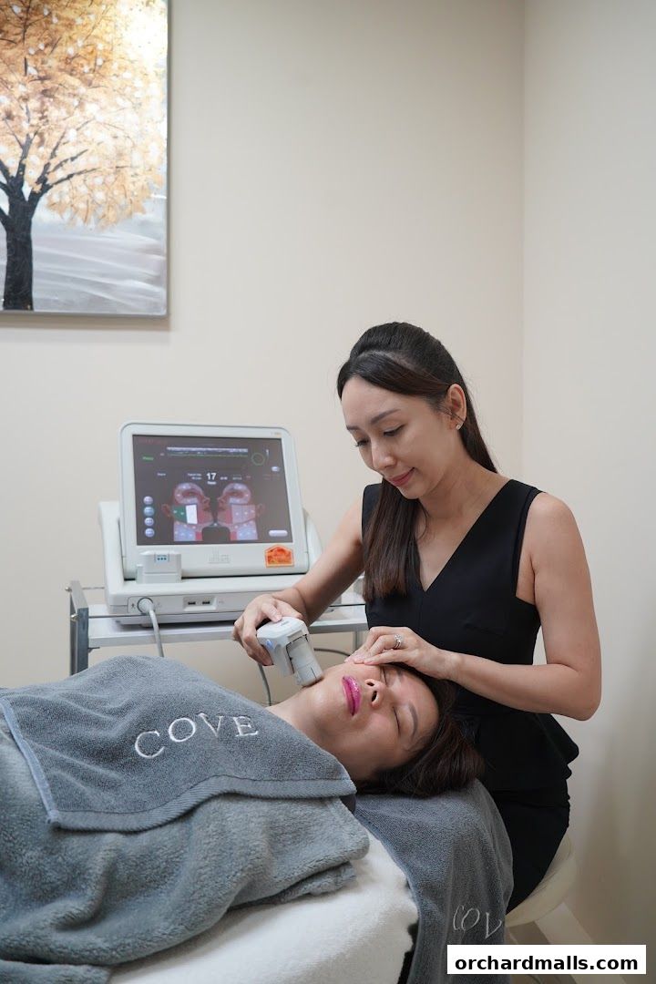 Aesthetician performing a facial treatment on a client with a device.