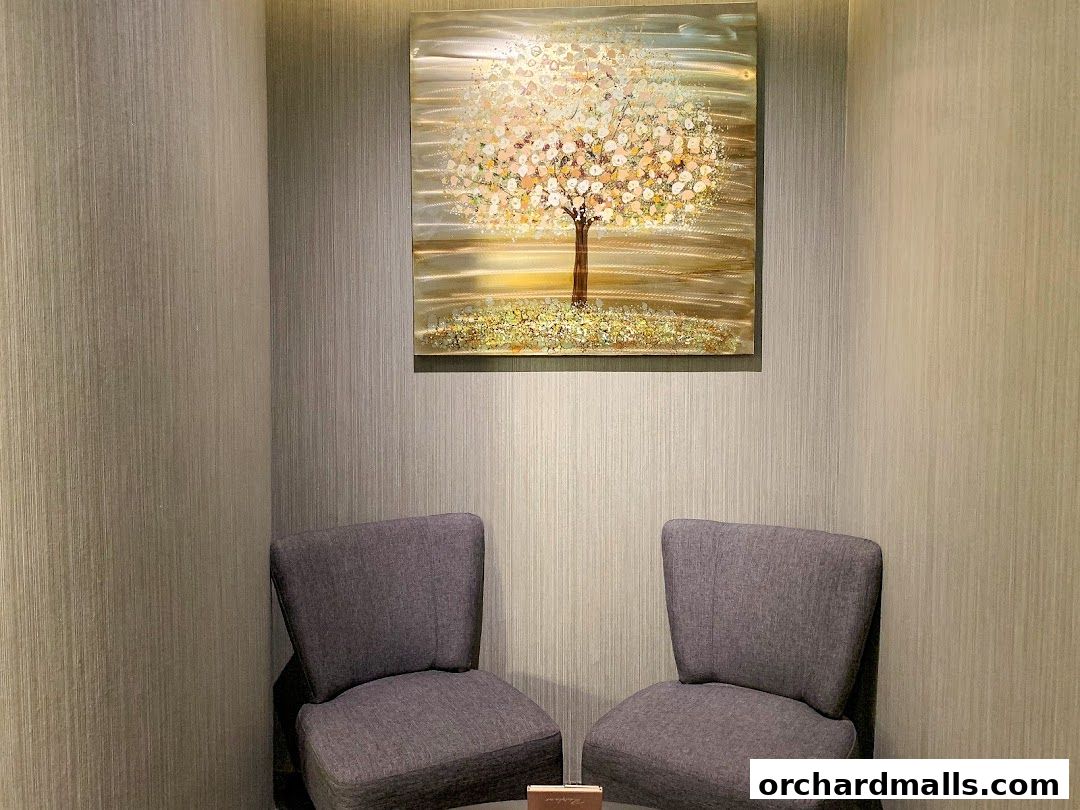 A waiting area with two chairs and a painting of a tree.