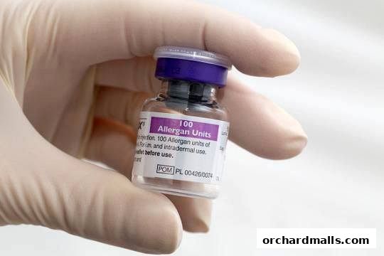 A gloved hand holds a vial of Allergan Units, likely for cosmetic treatments.