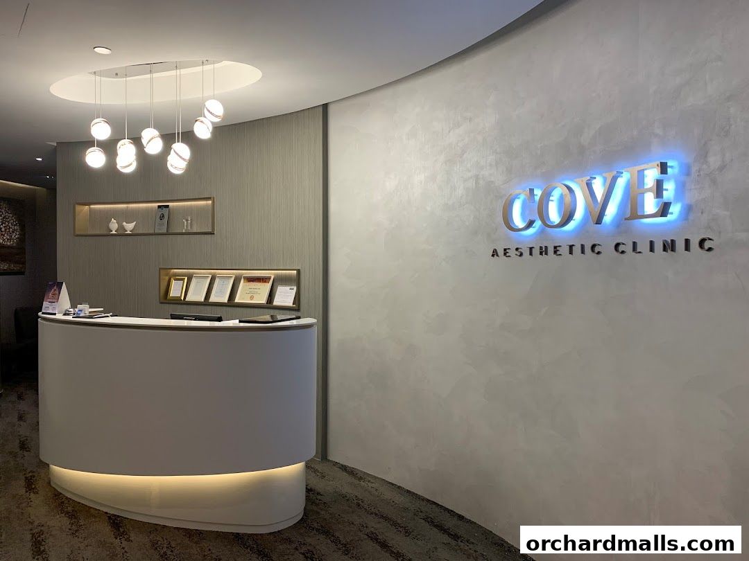 The reception area of Cove Aesthetic Clinic with a modern counter and illuminated logo.