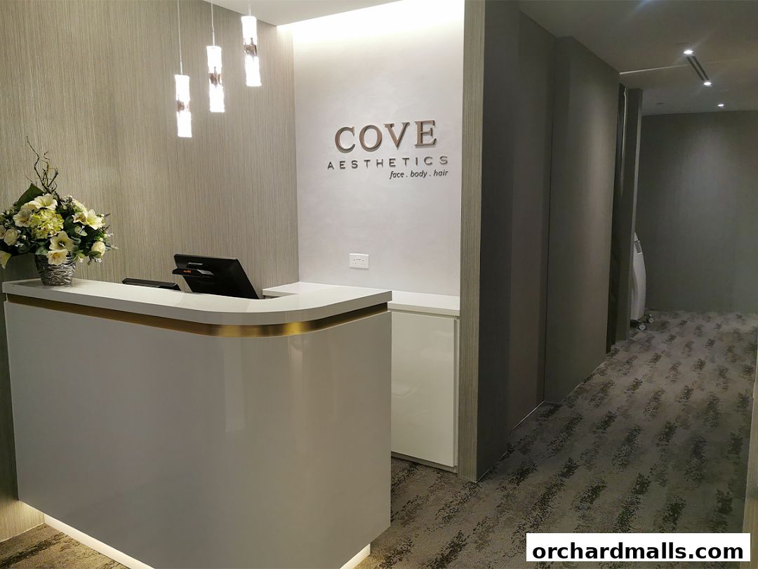 The reception area of Cove Aesthetics Medispa with a modern white counter and floral arrangement.