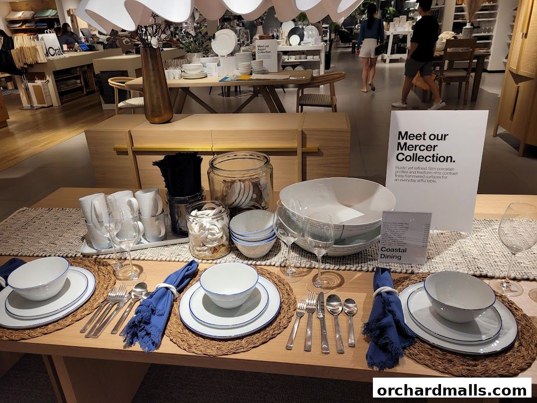 A Crate and Barrel store interior showcasing a beautifully set dining table with the Mercer Collection.