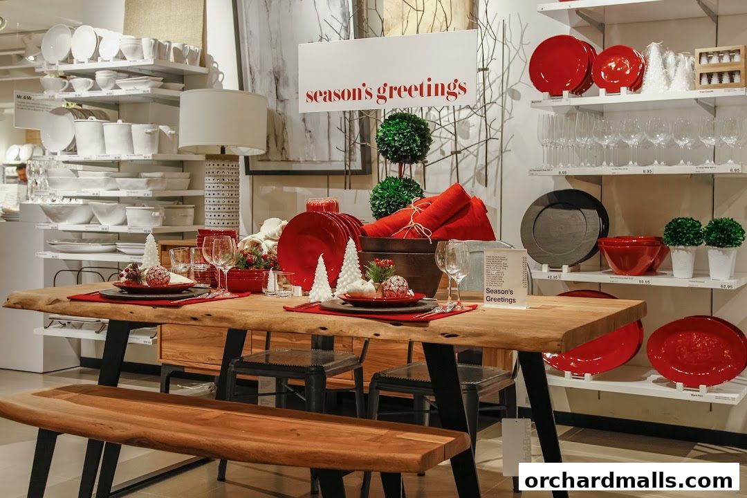 A dining table set for the holidays with red plates, festive decor, and glassware.