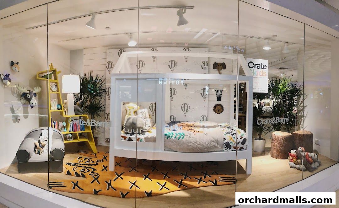 A Crate & Barrel store window display featuring a child's bedroom set with animal-themed decor.