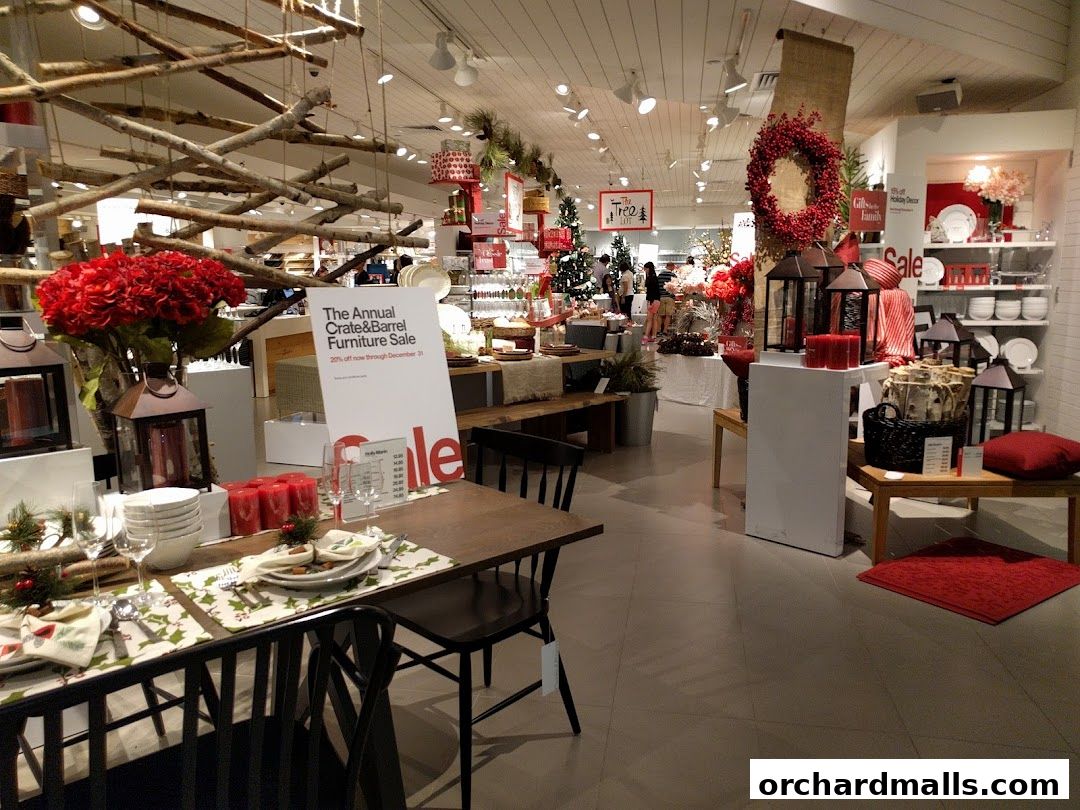 Interior view of a Crate and Barrel store decorated for the holidays with furniture and decor.