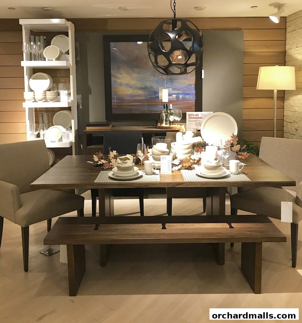 A dining table set with tableware and fall decor, displayed in a store.