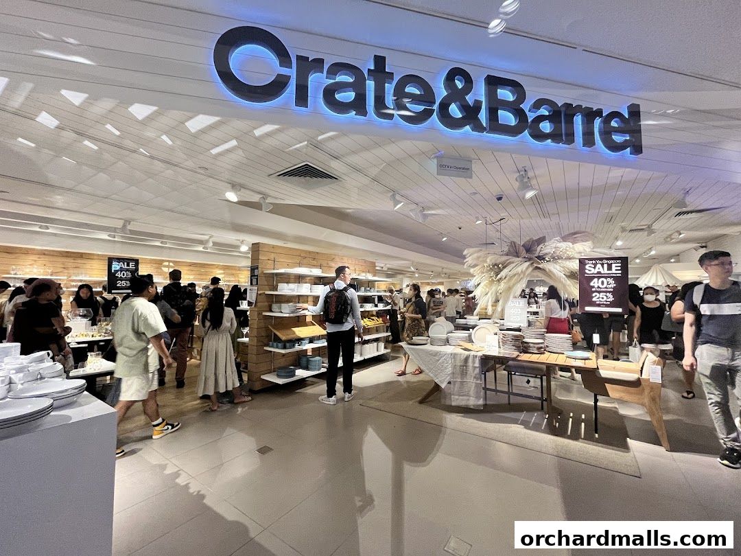 Interior view of a Crate and Barrel store with customers browsing home goods and tableware.