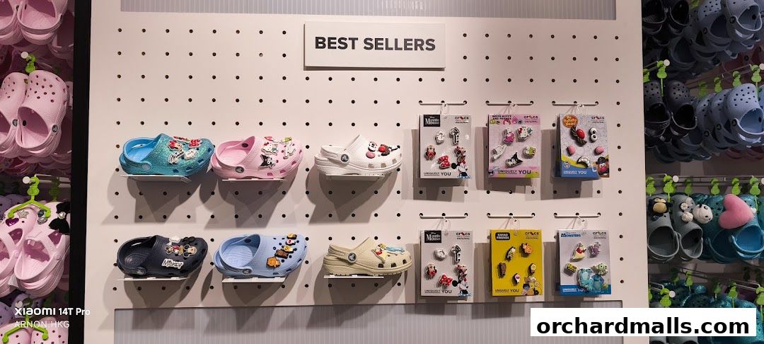 Crocs shoes and Jibbitz charms displayed on a pegboard wall, featuring popular characters.