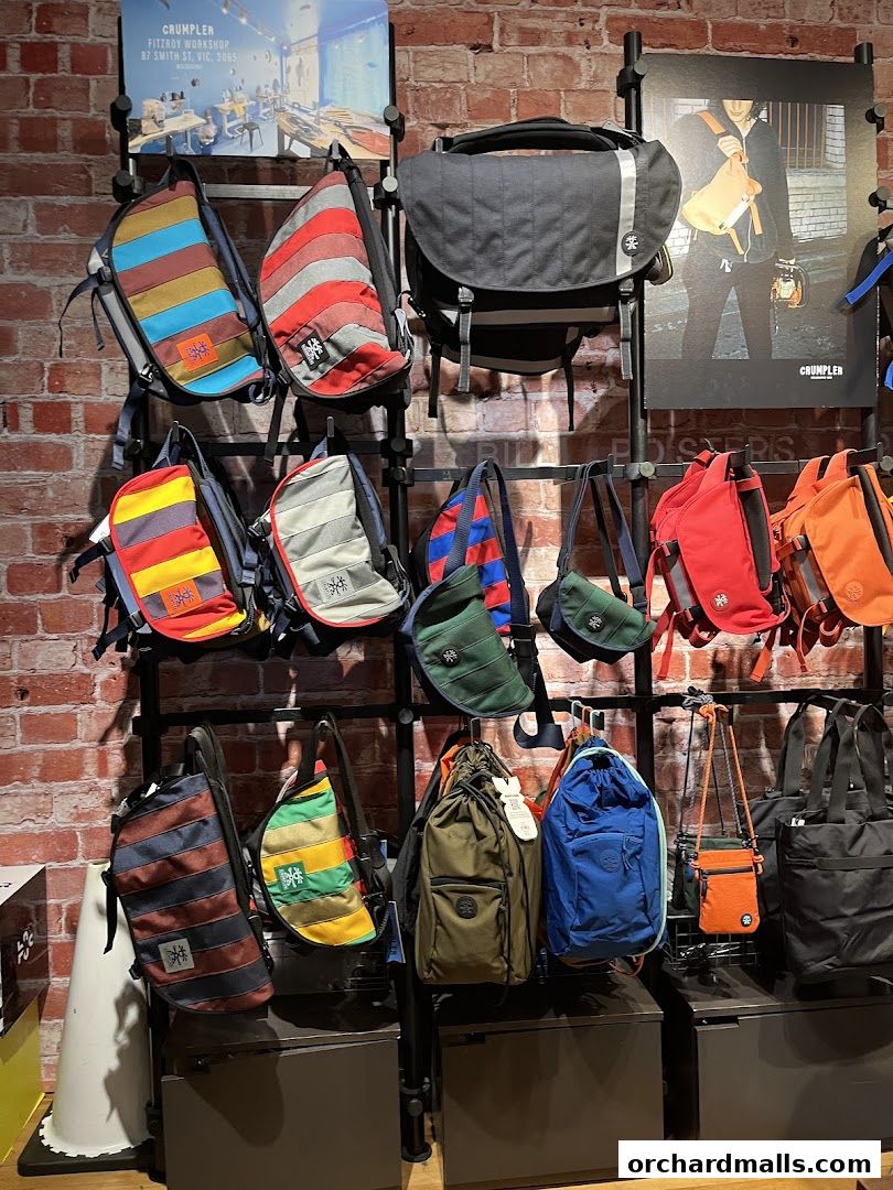 A wall display showcasing a variety of colorful and functional Crumpler bags.