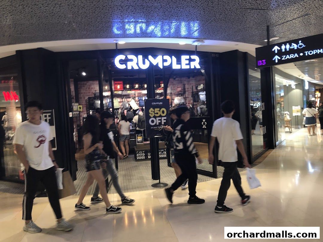 People walking past the Crumpler store entrance with a $50 off sign.