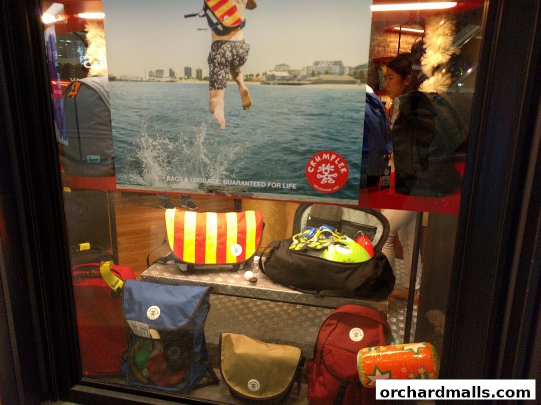 A shop window displaying various bags and a promotional image of a person jumping into water.