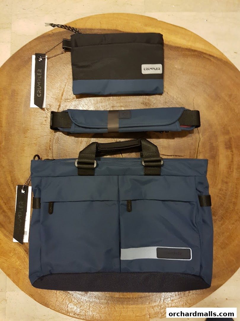 A collection of blue and black Crumpler bags, including a tote bag, a pouch, and a waist bag.