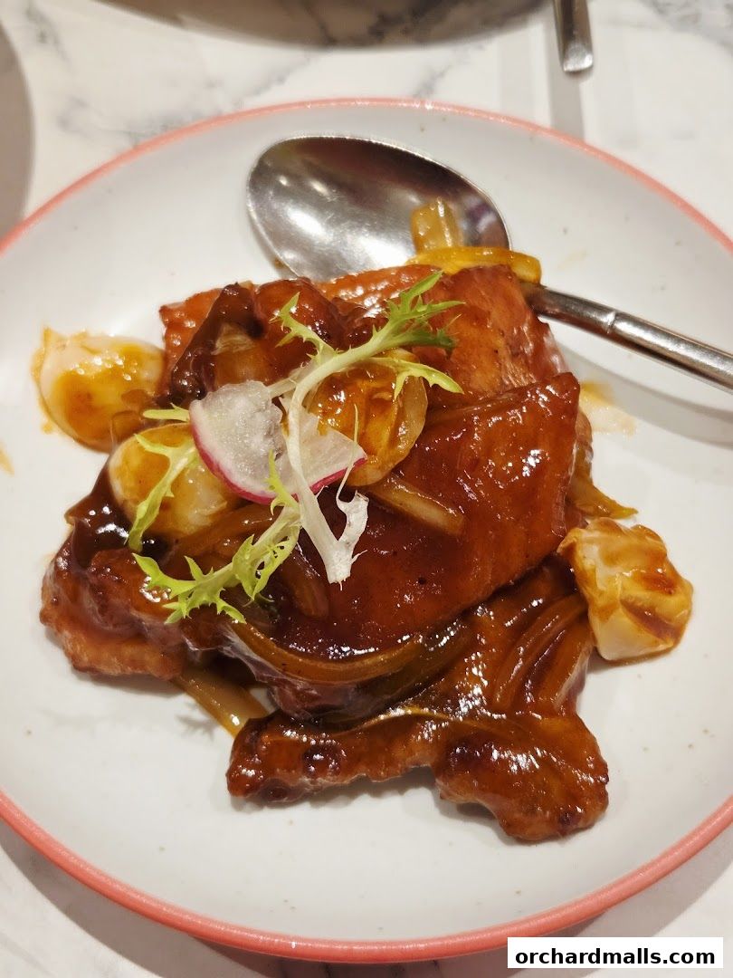 A close-up of a delicious dish with glazed meat and vegetables on a plate.