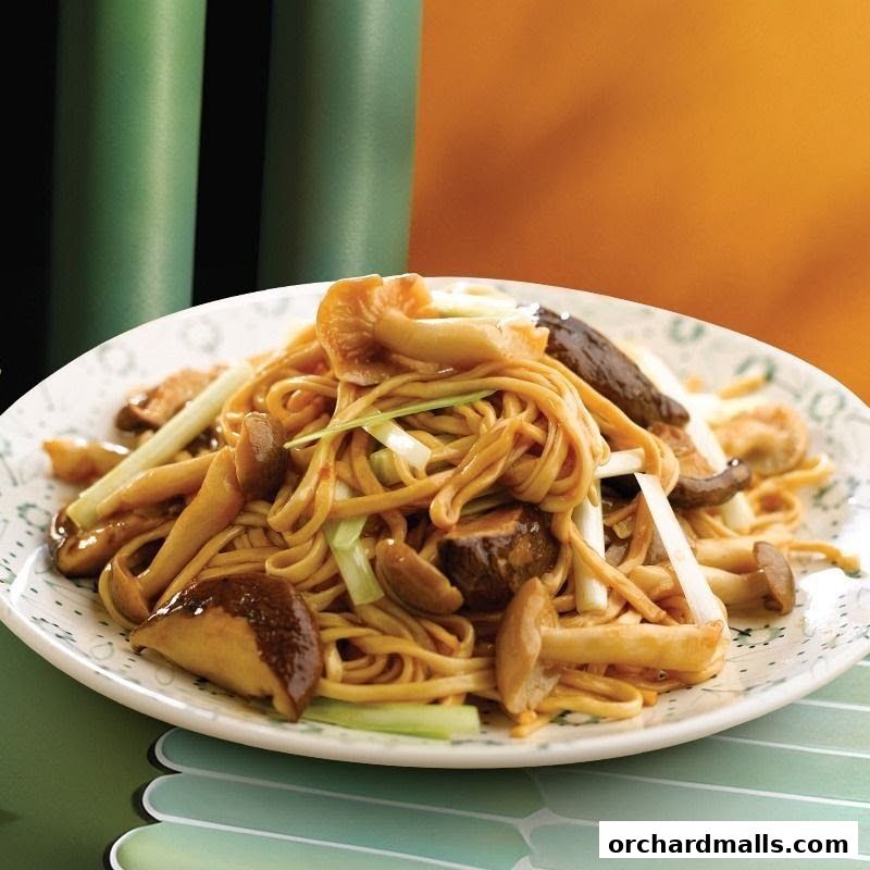 A plate of delicious mushroom noodles with fresh green onions.
