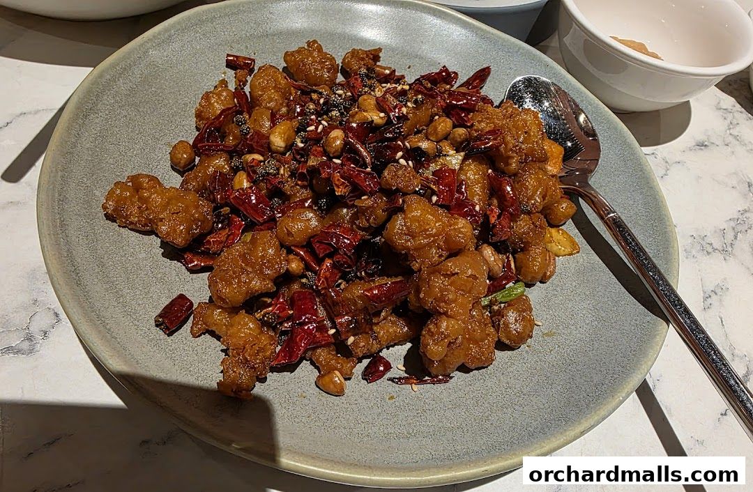 A plate of crispy fried chicken with dried chilies and peanuts.
