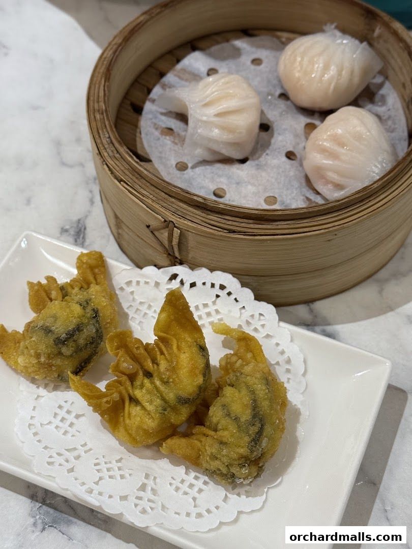 Steamed shrimp dumplings and crispy fried wontons served on a table.