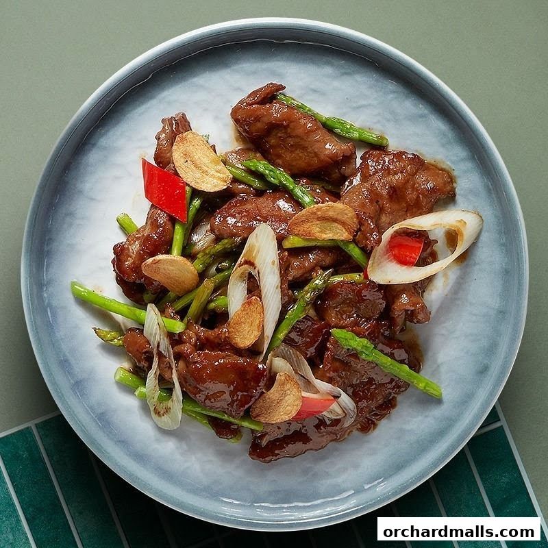 A close-up shot of a delicious stir-fried beef dish with asparagus and garlic.