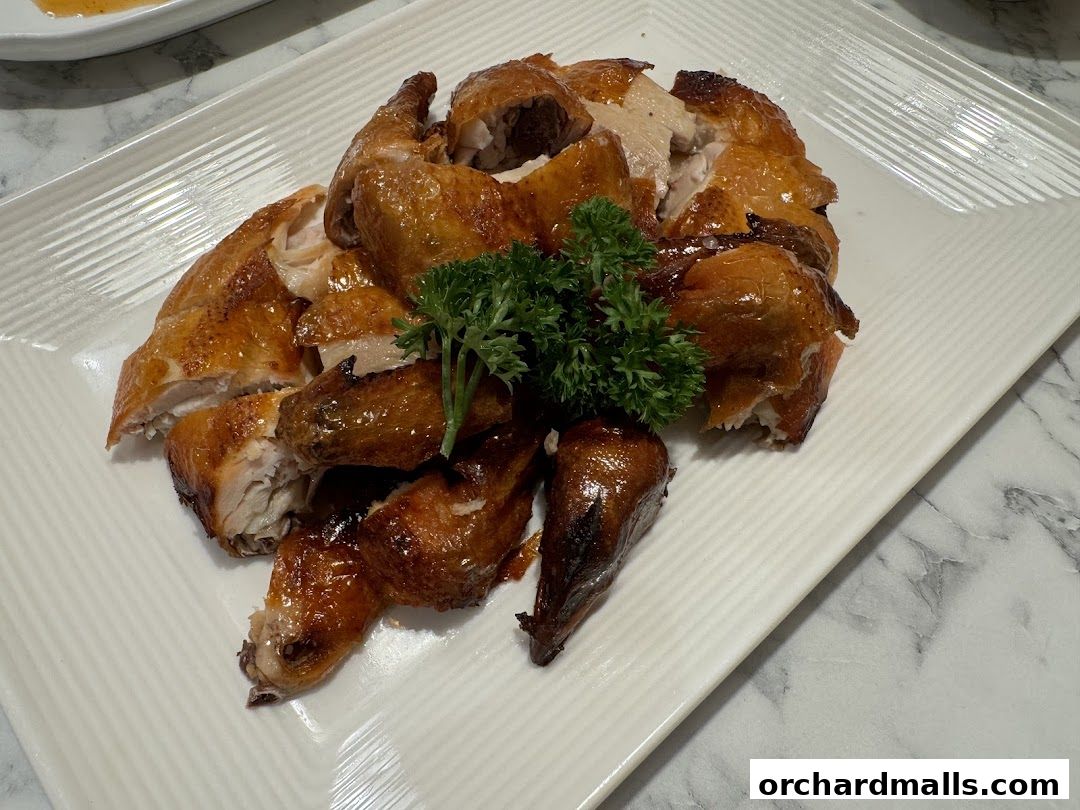 A platter of succulent, golden-brown roasted chicken, garnished with fresh parsley.