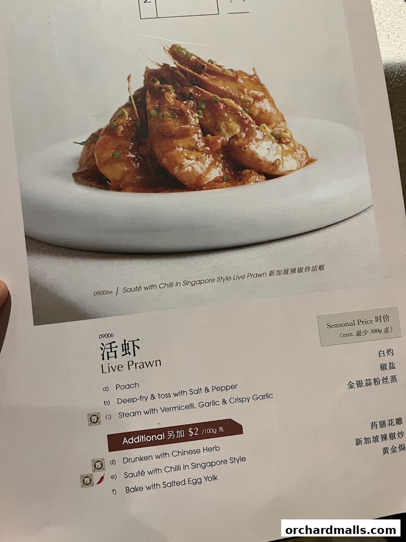 A menu page featuring a dish of sautéed live prawns with chili in Singapore style.
