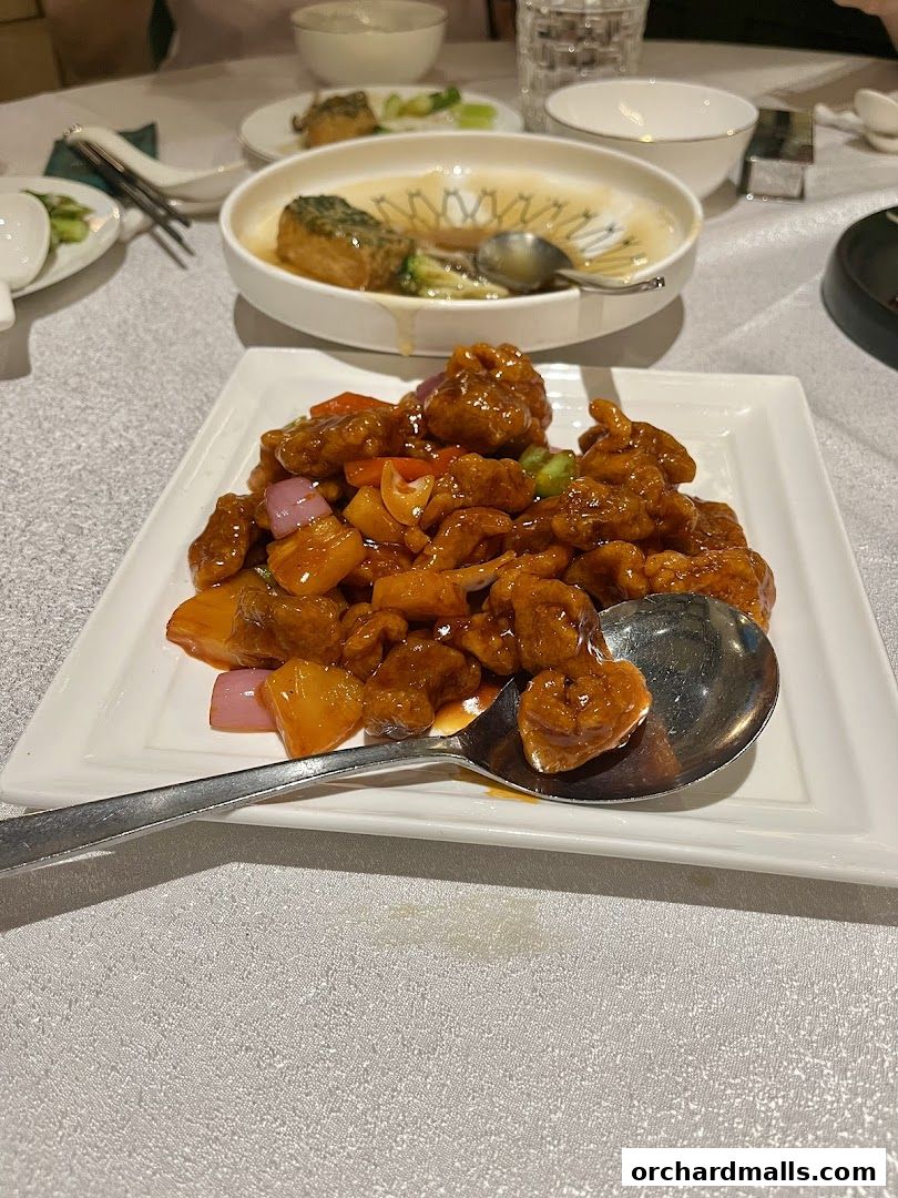 A plate of sweet and sour chicken with pineapple and vegetables served at Crystal Jade Palace.