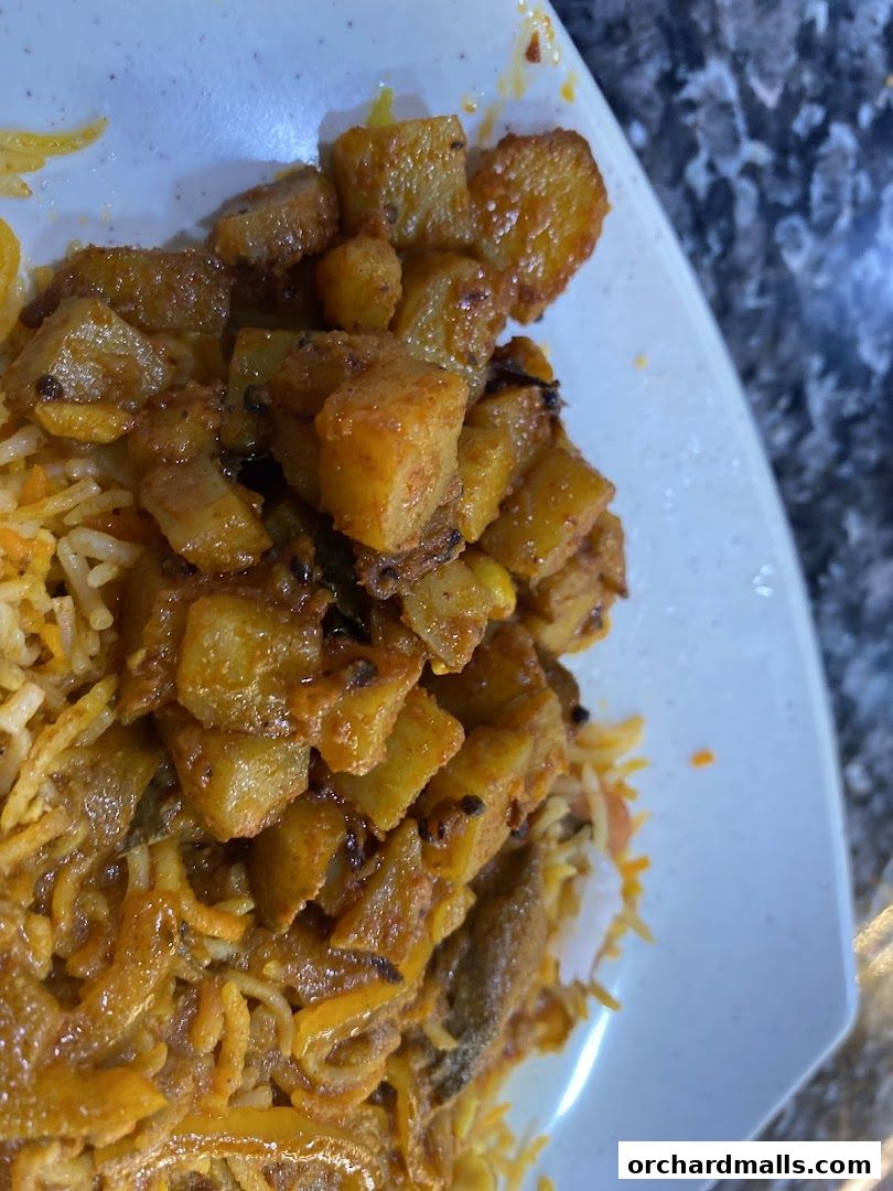 A close-up shot of a delicious Indian dish with rice and potato curry.