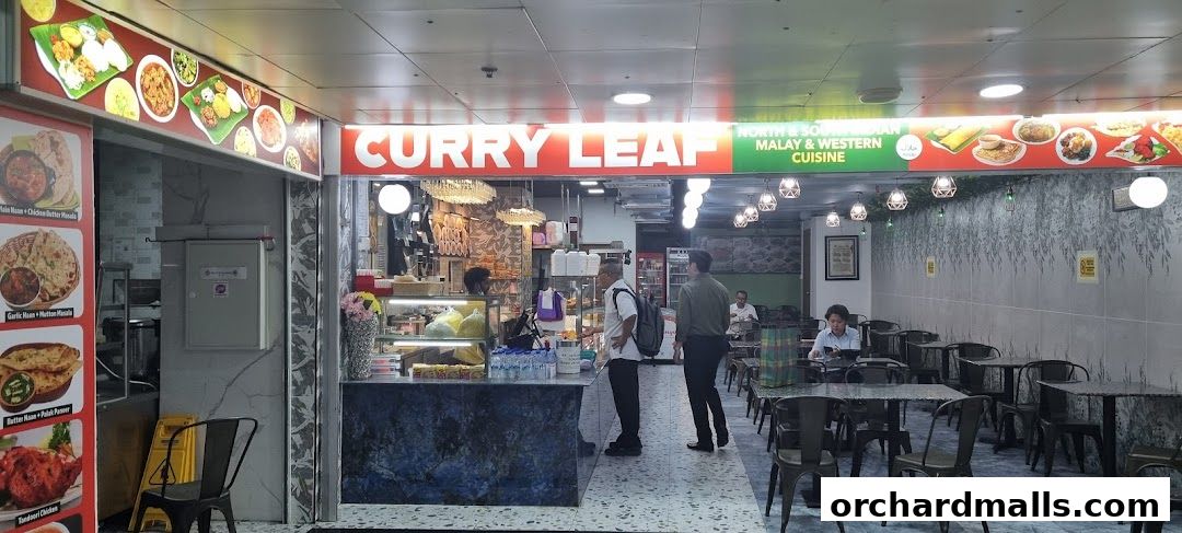 Exterior view of Curryleaf Multi Cuisine restaurant with food displays and seating area.
