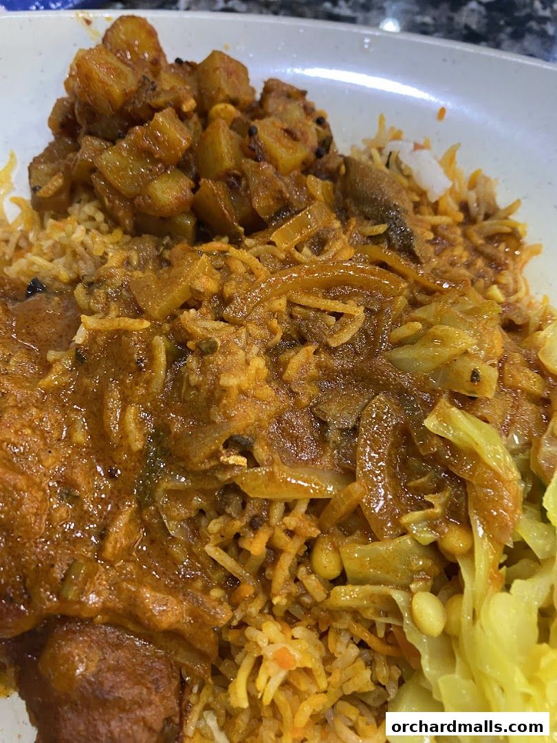 A close-up shot of a delicious Indian meal with rice, curry, and vegetables.