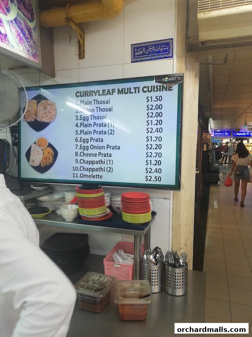 A digital menu board displays various South Indian dishes and their prices at Curryleaf Multi Cuisine.