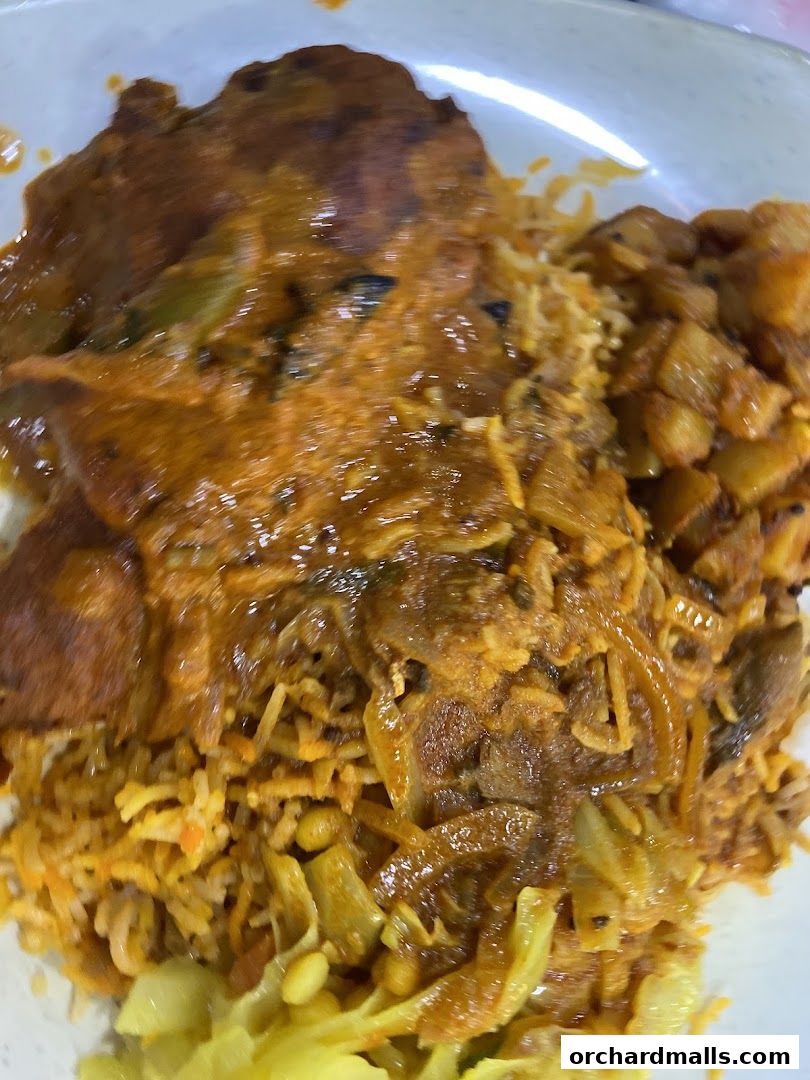 A close-up of a delicious Indian curry dish with rice and vegetables.