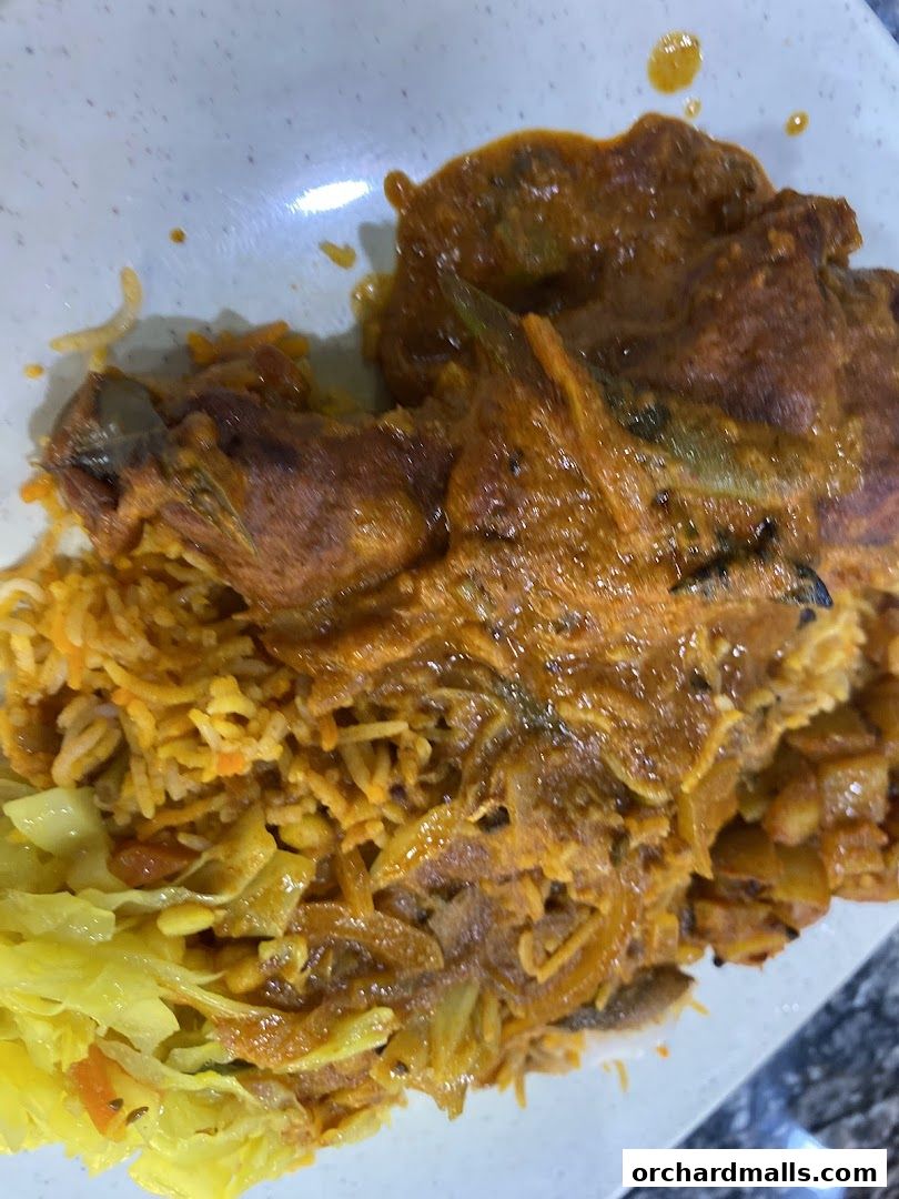 A plate of Indian food with rice, curry, and vegetables.