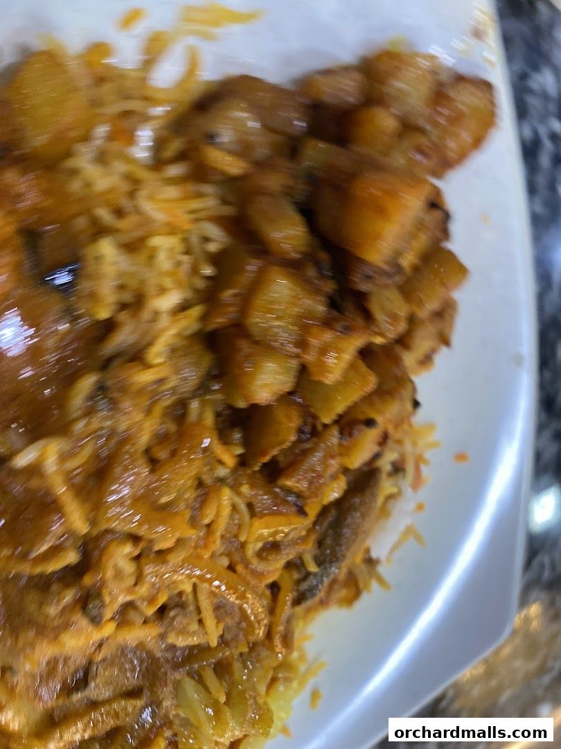 A close-up shot of a delicious biryani dish with tender meat and fluffy rice.