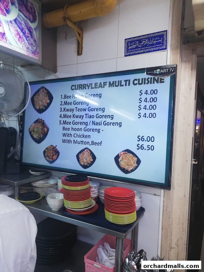 A digital menu board displaying various noodle dishes and their prices at Curryleaf Multi Cuisine.