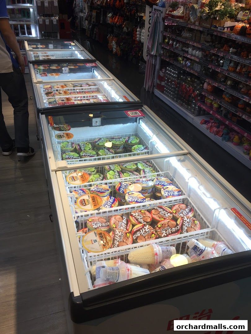 A display of frozen desserts, including ice cream cups and cones, in a retail store.