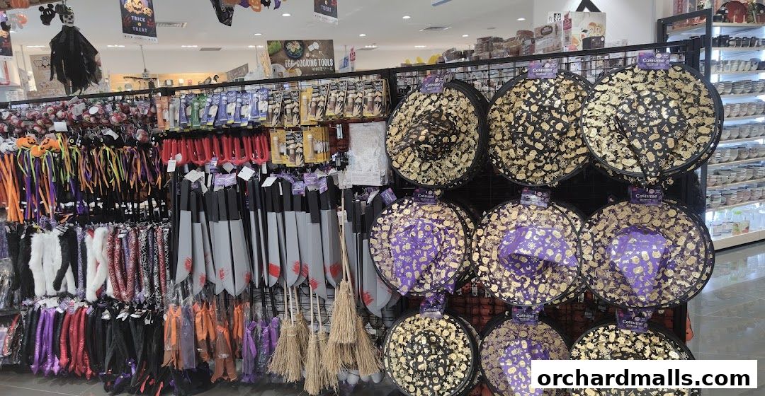 A display of Halloween-themed costumes and accessories, including witch hats and toy weapons.