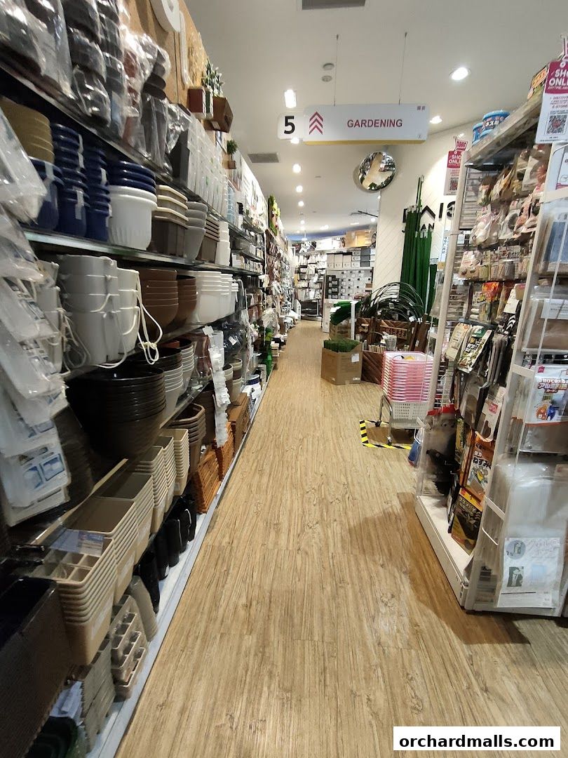 Aisle view of a Daiso store showcasing gardening supplies and various household items.