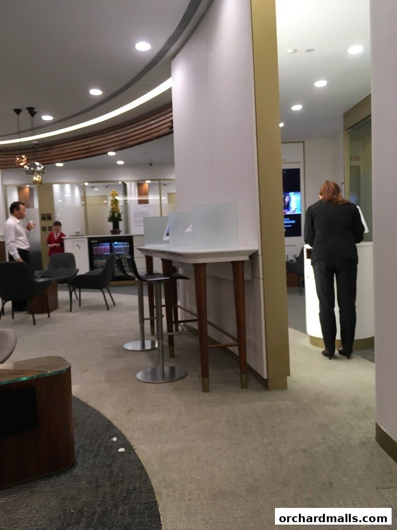 Interior of a modern bank branch with seating and digital displays.