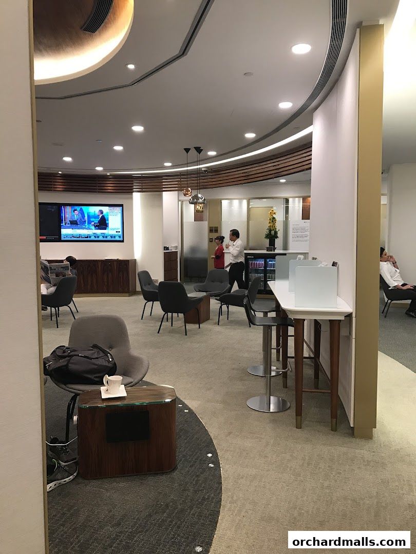 Interior of a modern lounge with seating, a TV, and a service counter.
