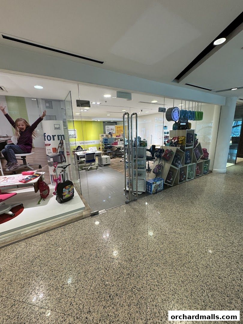 The exterior of a DHL Express Service Point and Ergokid store with displays of children's furniture and backpacks.