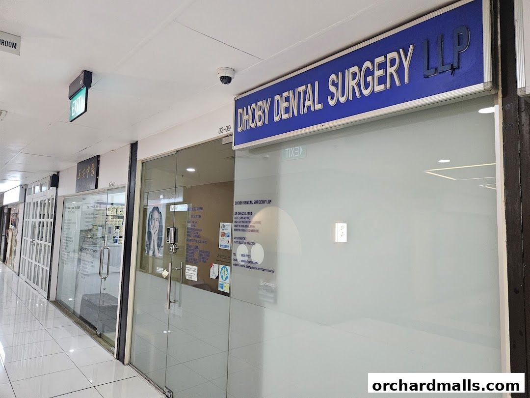 Exterior view of Dhoby Dental Surgery LLP with its signage and glass doors.