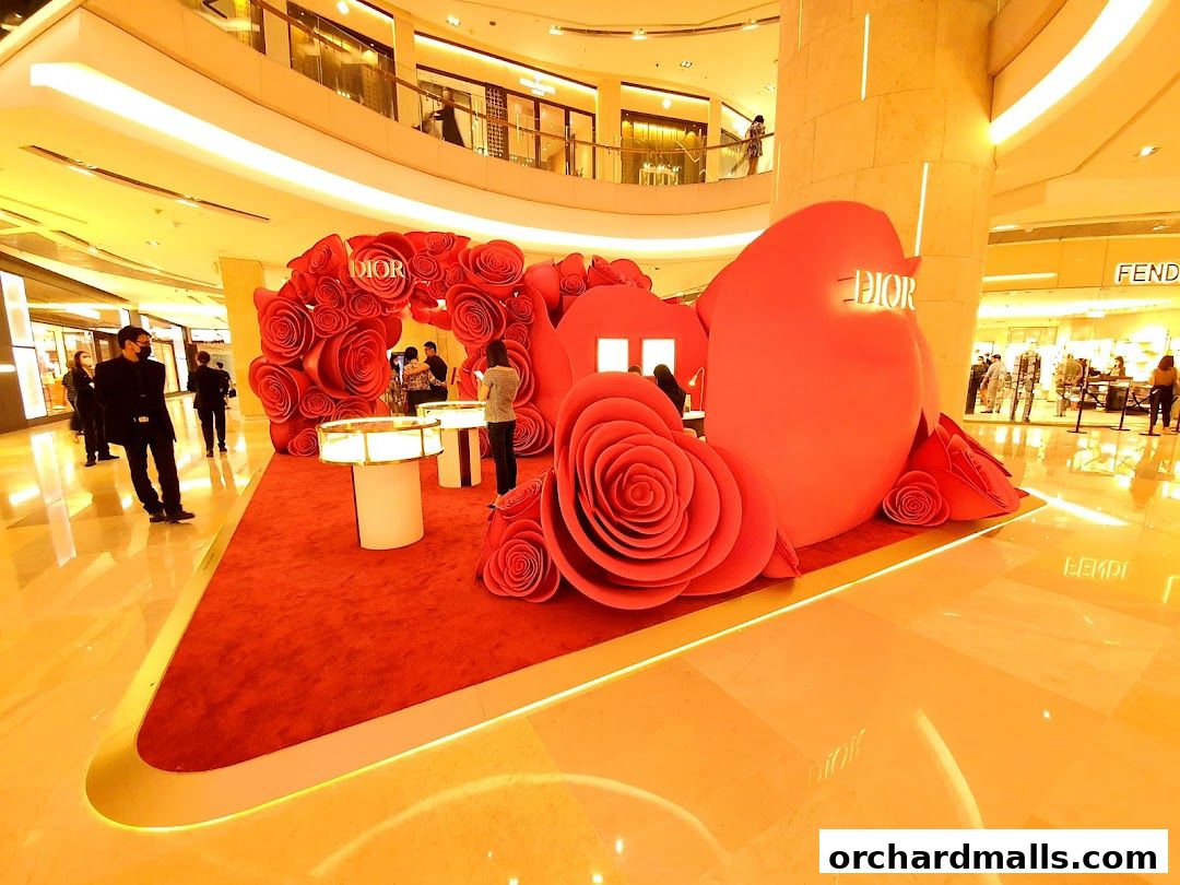 Dior Beauty boutique display with large red roses and a heart-shaped structure.