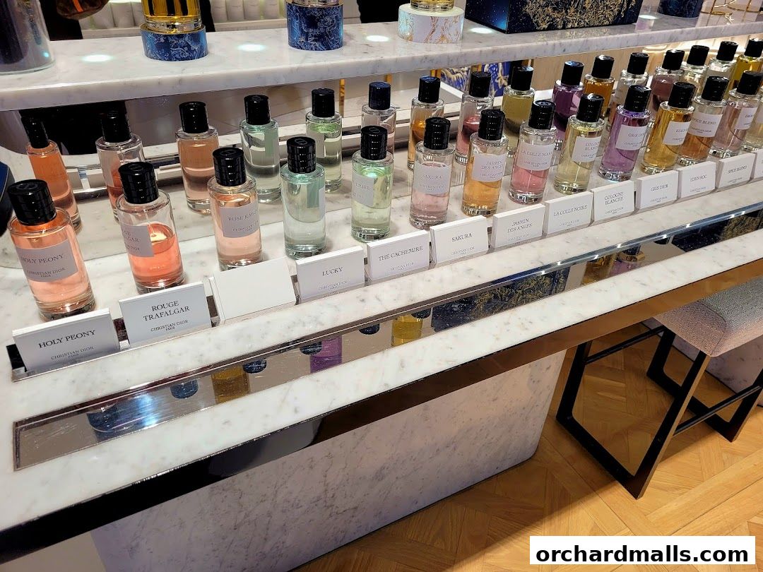 A display of various Dior fragrances in elegant bottles on a marble counter.