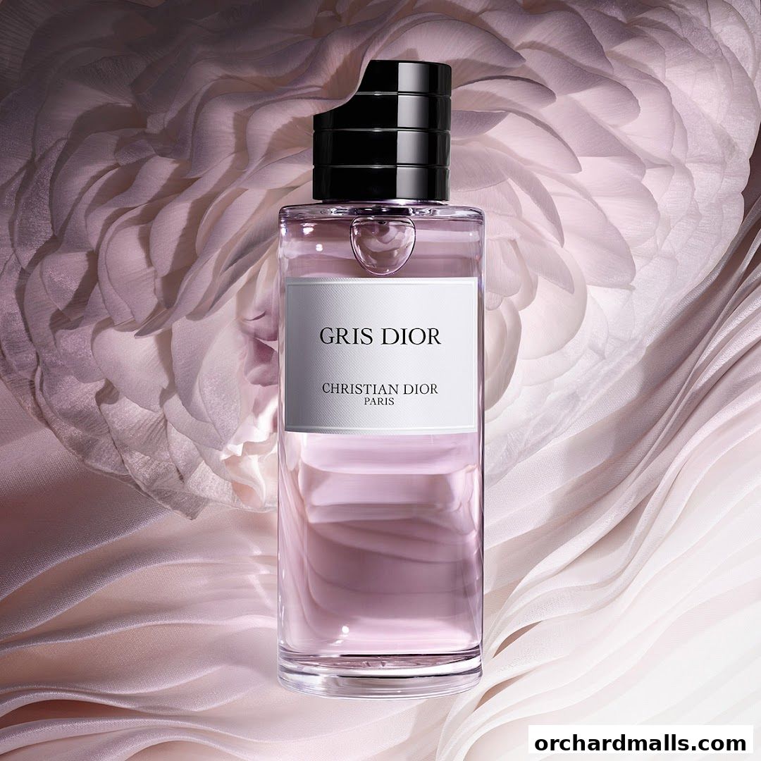 A bottle of Gris Dior perfume by Christian Dior Paris on a soft, draped fabric background.