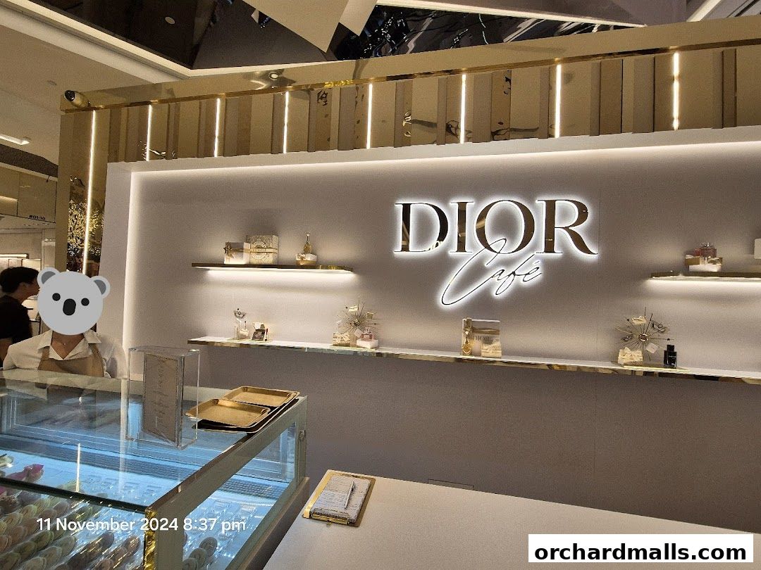 Interior of the Dior Cafe with illuminated logo and display shelves.