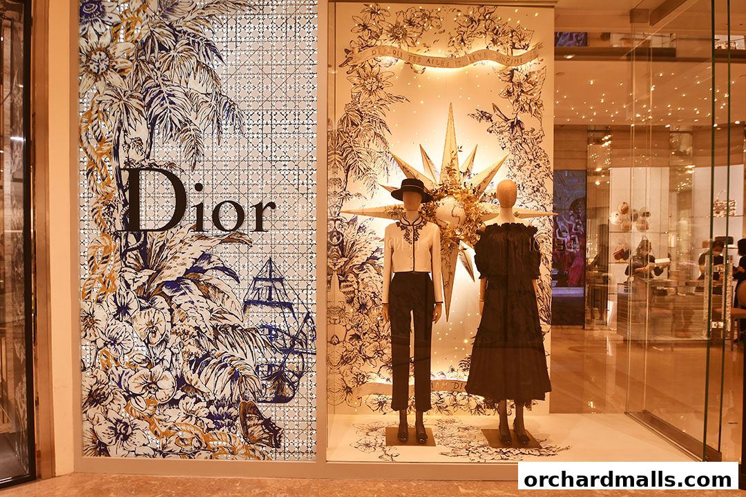 Dior Ngee Ann City storefront with mannequins displaying elegant fashion.