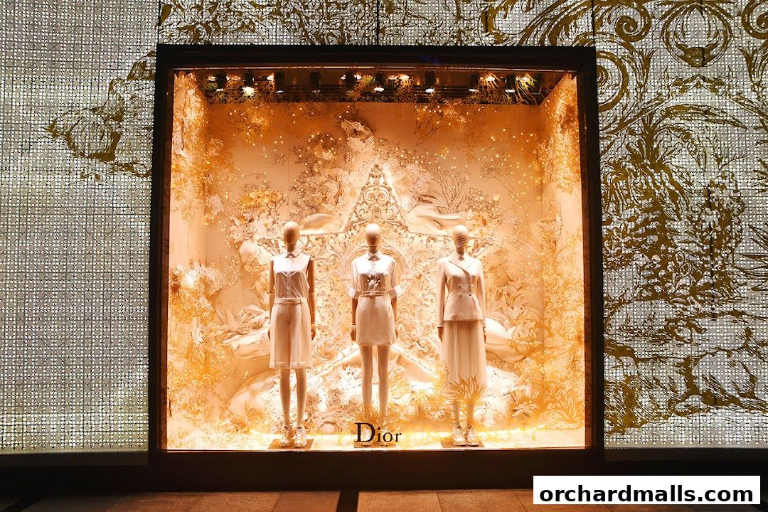 Dior Ngee Ann City shop window display featuring three mannequins in elegant white outfits.
