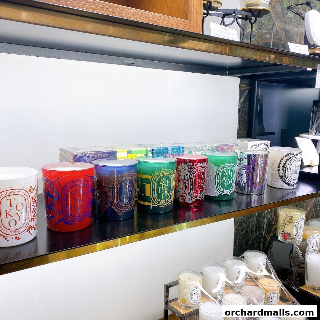 A display of Diptyque candles with city names on their labels.