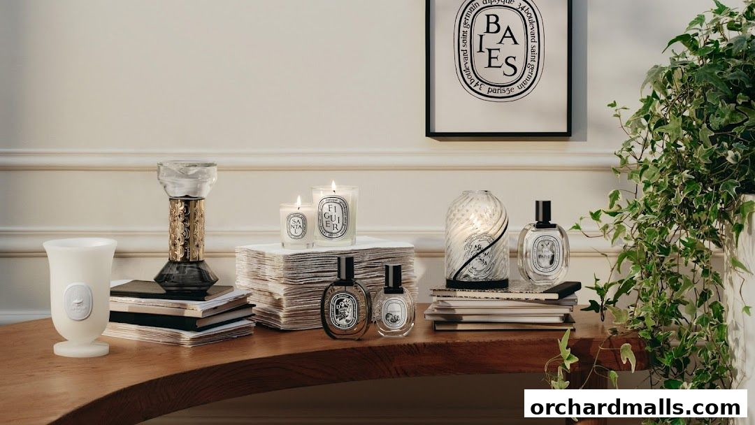 Diptyque candles, perfumes, and decorative items displayed on a wooden table.