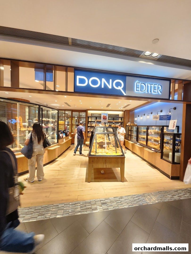 Interior view of a bakery shop with display cases filled with bread and pastries.